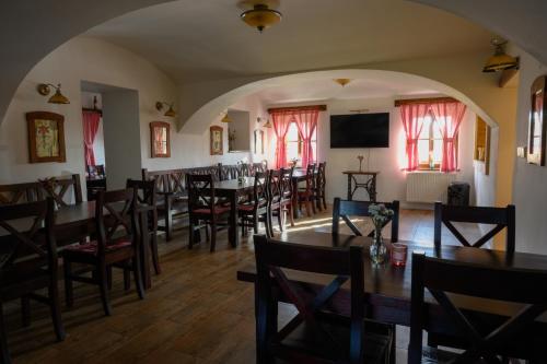 a dining room with tables and chairs and a television at Penzion Fryčovice in Fryčovice