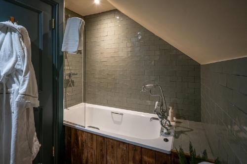 a bathroom with a bath tub with a sink at Castle Inn in West Lulworth