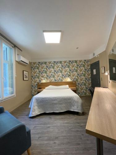1 dormitorio con 1 cama y 1 sofá azul en Hôtel Mistral Comédie Saint Roch, en Montpellier