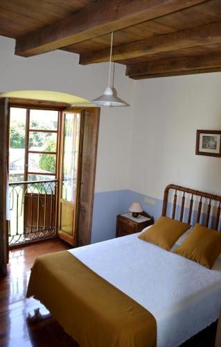 a bedroom with a bed and a balcony at Cabeza da Vila in San Martín de Oscos