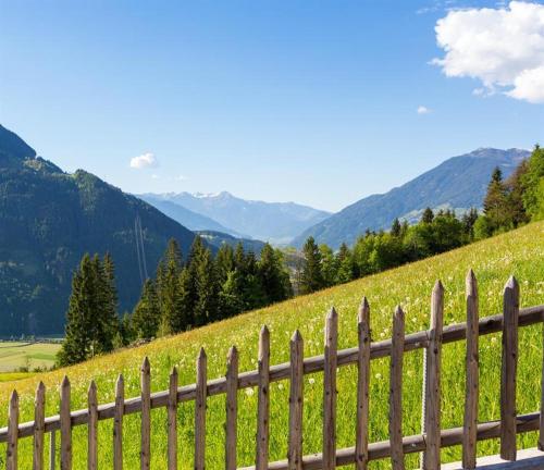 a fence on a hill with mountains in the background at Ferienwohnung Natural B in Gerlosberg