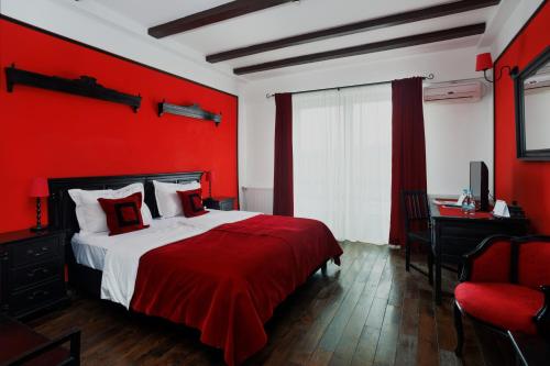 a red bedroom with a bed and a desk at Conacul Archia in Deva