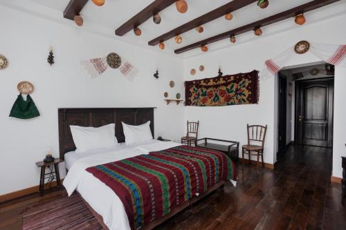 a bedroom with a large bed and two chairs at Conacul Archia in Deva