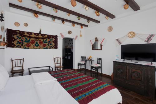 a bedroom with a bed and a flat screen tv at Conacul Archia in Deva