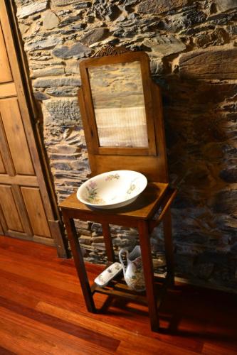 a plate on a stand next to a chair at Cabeza da Vila in San Martín de Oscos