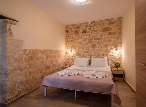 a bed in a room with a stone wall at Villa Lucas in Melidhónion