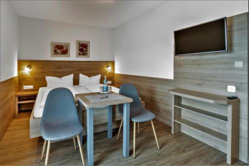 a hotel room with a bed and two chairs and a table at Gästehaus Arracher Hof in Arrach