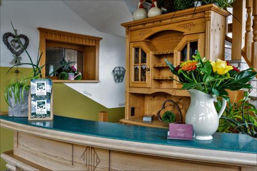 a counter with a vase with flowers on it at Gästehaus Arracher Hof in Arrach