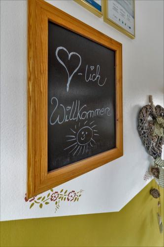 a chalkboard with a hello wilderness sign on a wall at Gästehaus Arracher Hof in Arrach