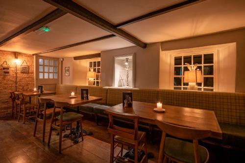 a restaurant with wooden tables and chairs and a couch at Castle Inn in West Lulworth