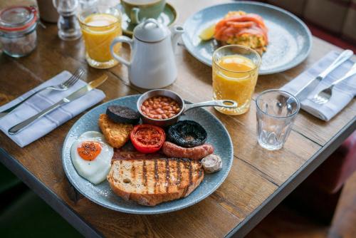 a table topped with plates of breakfast foods and drinks at Castle Inn in West Lulworth