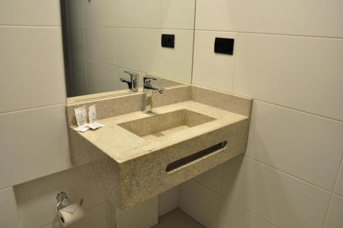 a bathroom with a sink and a mirror at Hotel Peregrinos in Aparecida