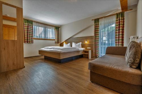 a hotel room with a bed and a couch at Gästehaus Arracher Hof in Arrach