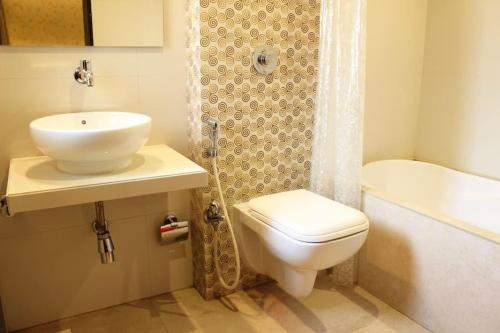 a bathroom with a toilet and a sink and a tub at HOTEL SHARADA INTERNATIONAL in Thane