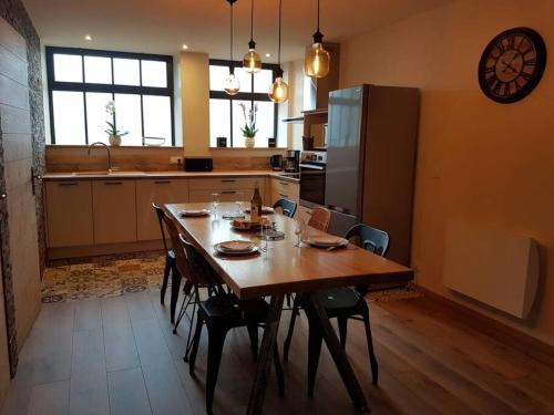 une cuisine avec une grande table en bois et des chaises dans l'établissement Gite du Cours St Mauris Authentique et moderne, à Dole