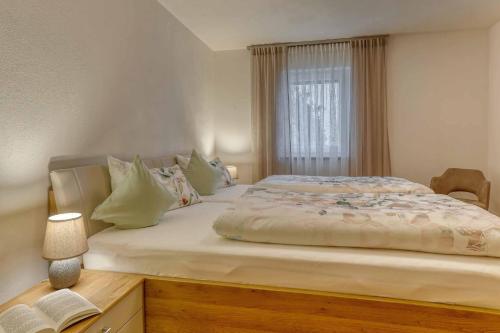 a bedroom with a large bed with a window at Ferienwohnung Lankl im Bayerischen Wald in Röhrnbach