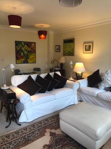 a living room with two white couches and a couch at Chichester Holiday Lets in Chichester