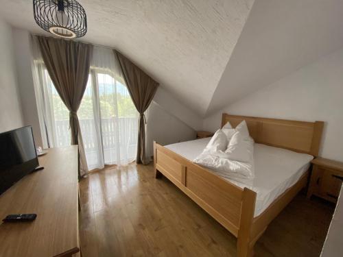 a bedroom with a bed and a large window at Casa Lazaroiu in Curtea de Argeş