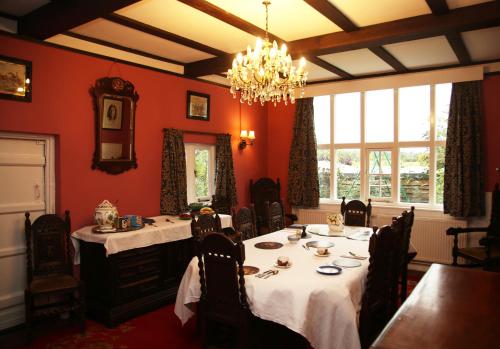 a dining room with two tables and a chandelier at Inverloddon Bed and Breakfast, Wargrave in Reading