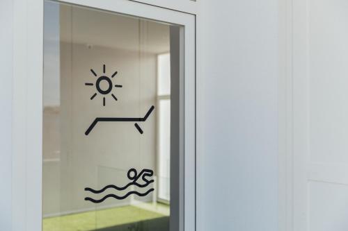 a glass door with a picture of a sun and waves at BN SUITES Teatro in Alicante