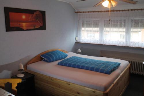 a bedroom with a wooden bed with blue pillows at Gasthaus Zur Sonne in Freiburg im Breisgau
