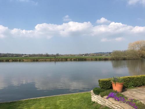 een uitzicht op een waterlichaam met struiken en bloemen bij Inverloddon Bed and Breakfast, Wargrave in Reading