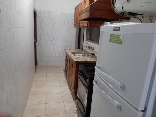 uma cozinha com um frigorífico branco e um fogão em Eduardo em Malargüe