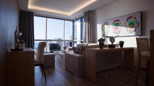 a living room with a couch and a large window at The Stay Furnished Apartments in Dbayeh