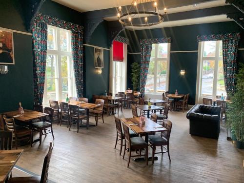 a dining room with tables and chairs and windows at The Mount B&B in Malton