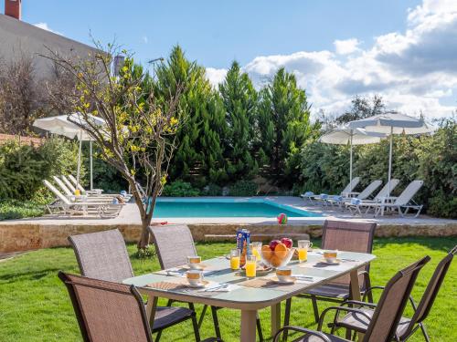 a table with drinks on it next to a pool at Villa Lucas in Melidhónion