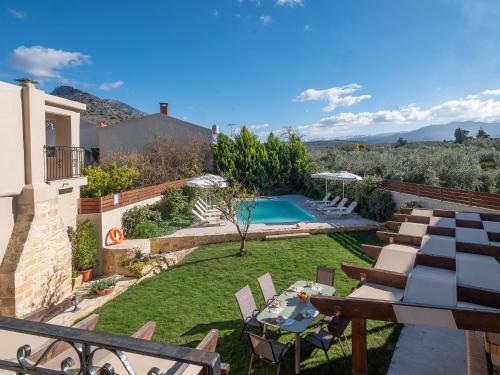 a backyard with a swimming pool and a villa at Villa Lucas in Melidhónion