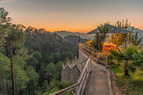 a view of a mountain with a sunset in the background at Kanishka Retreat Resort Chail in Chail