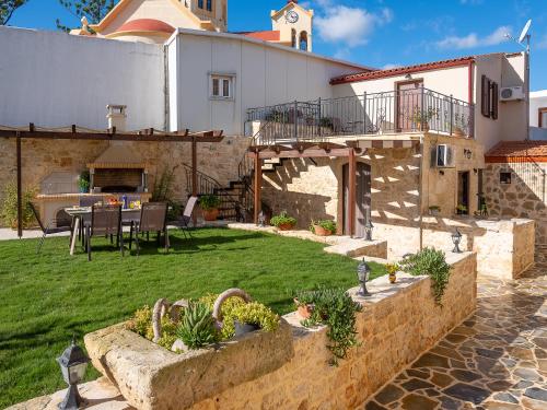 a house with a courtyard with a table and chairs at Villa Lucas in Melidhónion