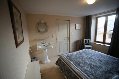 1 dormitorio con cama, lavabo y ventana en Chez Jean Pierre - Couple room in a 17th century house - n 1, en Villar-dʼArène