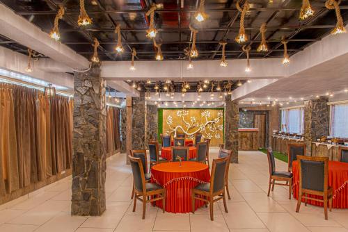 a dining room with a red table and chairs at Kanishka Retreat Resort Chail in Chail