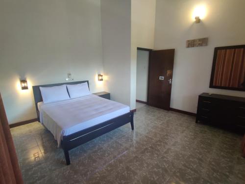 a bedroom with a bed and a television in it at Green Village Negombo in Ettukala
