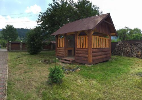 a small wooden cabin in a grassy yard at Приватний котедж «Наш Черемош», с.Ільці in Iltsi