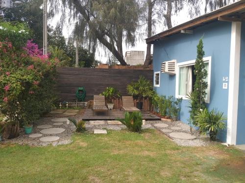 un patio con sillas y una casa azul en Casa na praia do Campeche, en Florianópolis