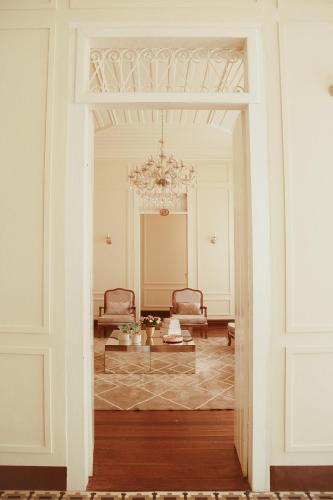 a hallway leading to a living room with a chandelier at Pousada Encantos de Palmeiras in Palmeiras