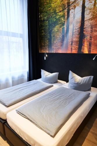 two beds in a bedroom with a painting on the wall at Novitel Hotel Kirchheim - München Messe in Kirchheim