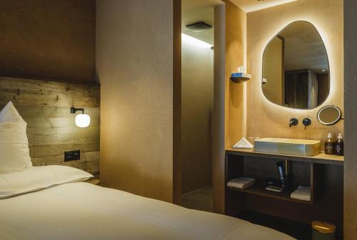 a bedroom with a bed and a sink and a mirror at the rex in Zermatt