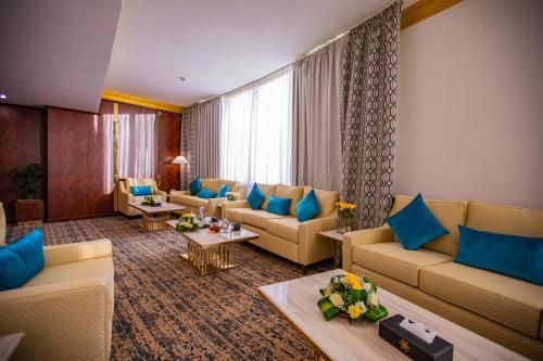- un salon avec des canapés et des oreillers bleus dans l'établissement Le Park Concord Hotel & Resident Najran, à Najran