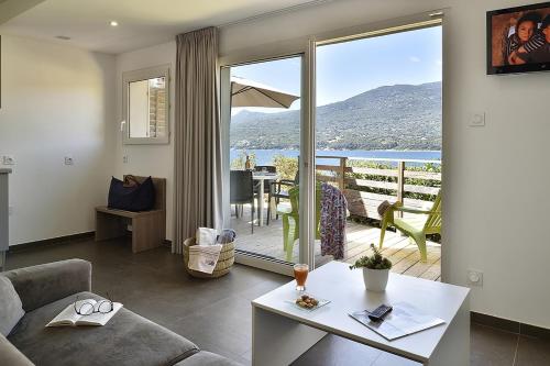 een woonkamer met uitzicht op de oceaan bij Hôtel Sampiero Corso in Propriano
