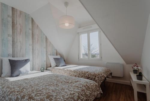 une chambre avec deux lits et une fenêtre dans l'établissement Appartement 2 chambres aux portes de Deauville 100m du Pôle International du cheval, à Saint-Arnoult