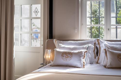 a white bed with white pillows and a window at B&B Sterckxhof in Meise