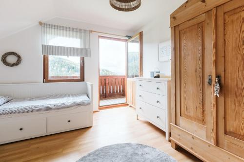 a bedroom with a bed and a window at mirnockAHOI - familienfreundliches Ferienhaus für 4 Erwachsene, maritimes Bergerlebnis, Panoramablick von Terrasse und Balkon, Carinthia, Millstättersee in Ferndorf