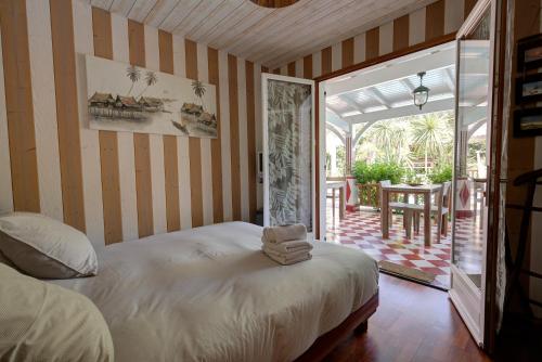 a bedroom with a bed and a patio with a table at la Varangue in Lacanau