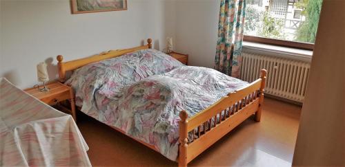 1 dormitorio con cama de madera y ventana en FeWo Krehberg, en Lindenfels