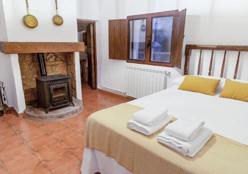 a bedroom with a bed and a fire place at Casa rural El Molino de Bogarra in Bogarra