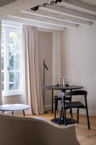 a table and chairs in a room with a window at B&B Sterckxhof in Meise
